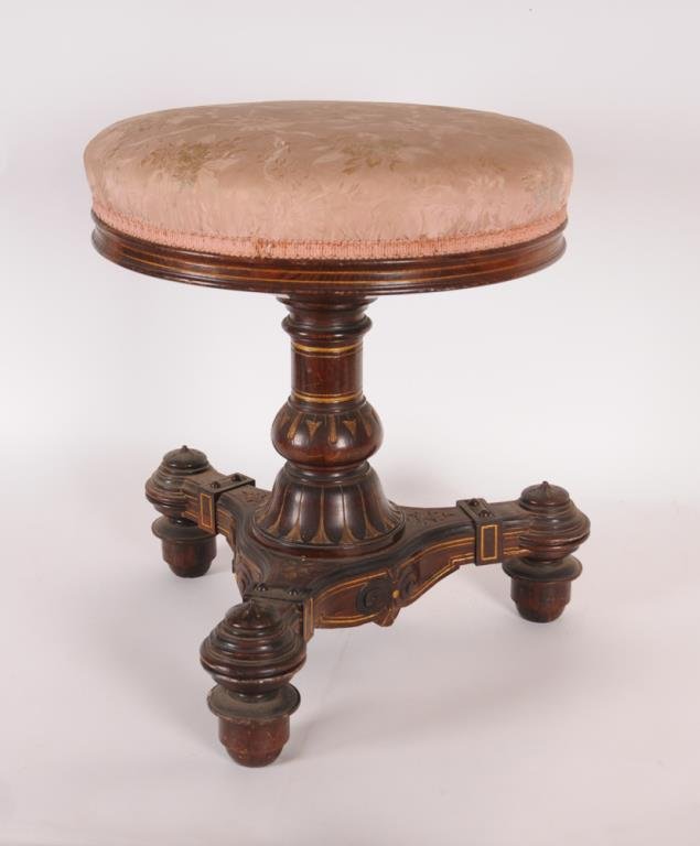 Renaissance Revival Carved Piano Stool American, third: American, third quarter century, extensively carved columnar support and tripod base, remnants of gilt decoration, round adjustable upholstered seat, 16" dia., soiling to upholstery