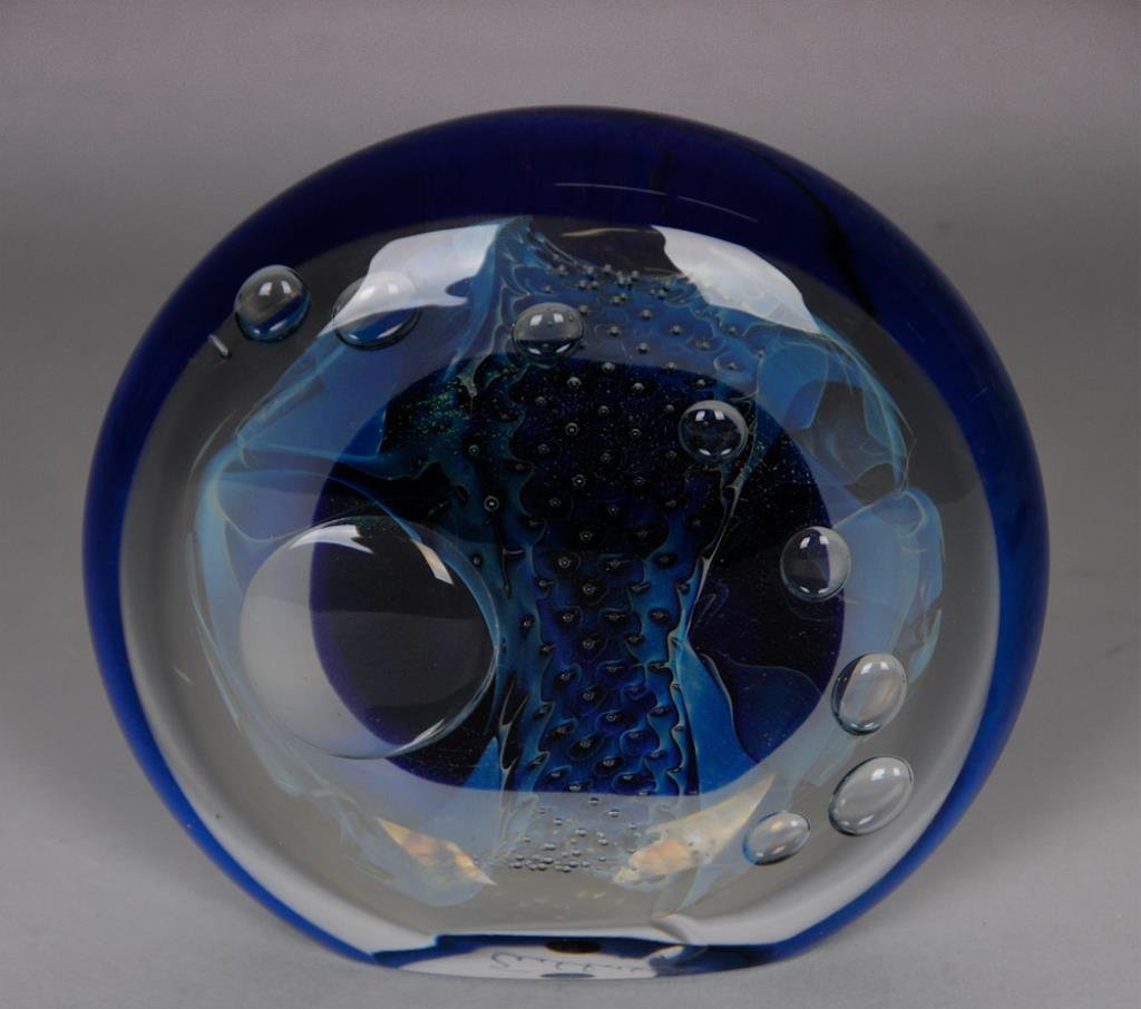 Large Robert Eickholt Art Glass Paperweight: Large disc paperweight featuring an iridescent metallic blue/purple shape at center, accented with thin sheets of dichroic glass and controlled bubbles; etched on base "Eickholt 1991"; height 6 1/4 in