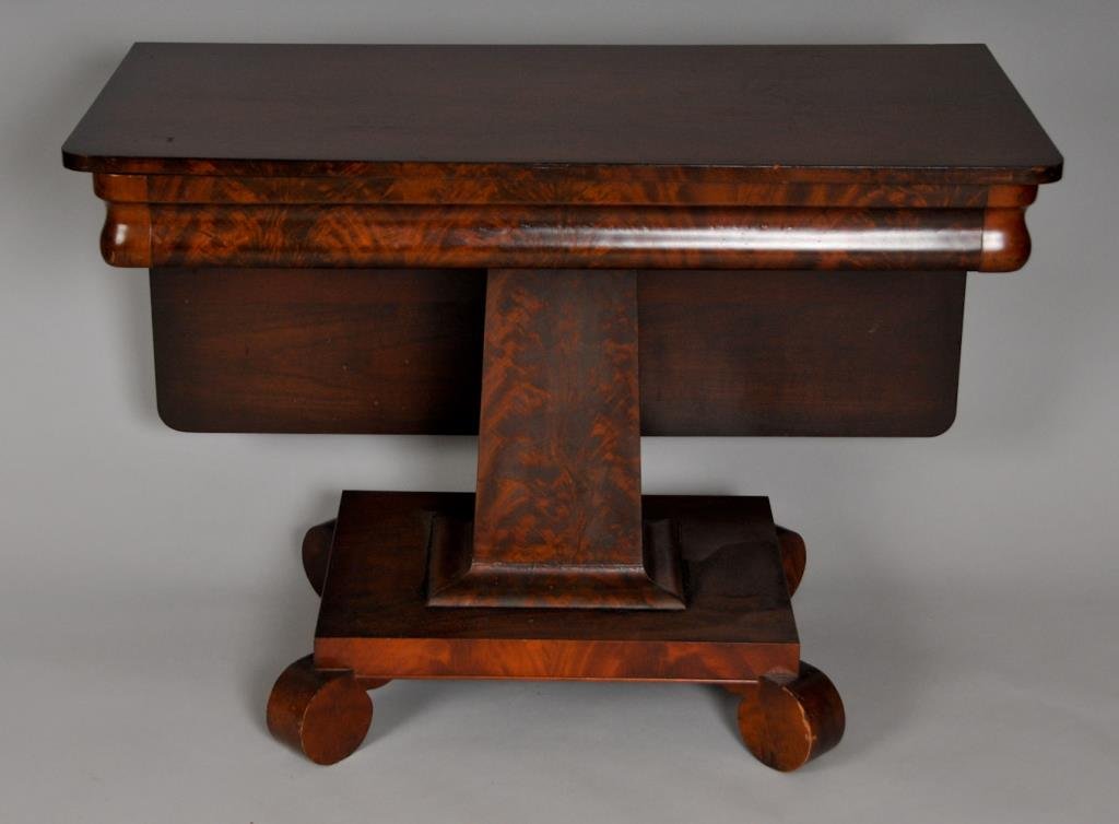 American Late Classical Mahogany Drop-Leaf Table: c. 1840, rectangular swivel top with a single drop leaf, ogee molded skirt, tapered pedestal on rectangular base with four rounded and scrolled feet; closed 40 1/2"W x 20 3/4"D, opens to 39 3/4" x 40 