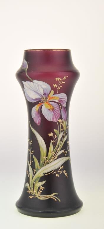 French Enameled Art Glass Vase: Decorated with blooming iris on a purple ground, concave shoulder with hourglass body, unsigned, probably French, early 20th century; height 10 3/4 in.; good condition with wear to gilt band at rim (I