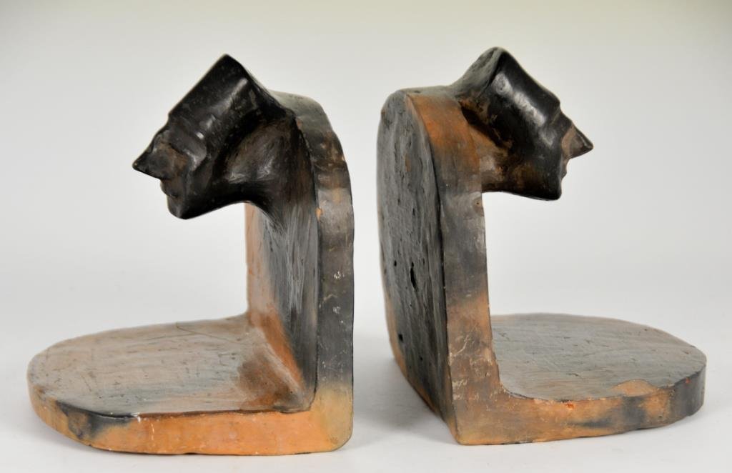 Pr. of Catawba Indian Pottery Bookends: Pair of molded earthenware bookends, each featuring a Chief's head with headdress; 5 1/4"W, 4 1/2"D, 5 1/2"H; chips to edges as pictured, one with firing crack