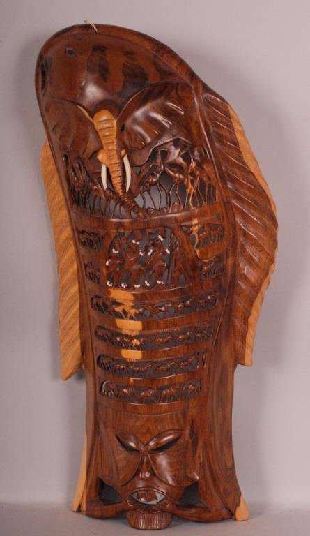 African Totem Carved Wood Wall Hanging: Carved in the shape of a fish and having six horizontal rows of carved openwork figures and animals, figures with beaded accents, elephant head with tasks carved in relief at top and mask carved at bo