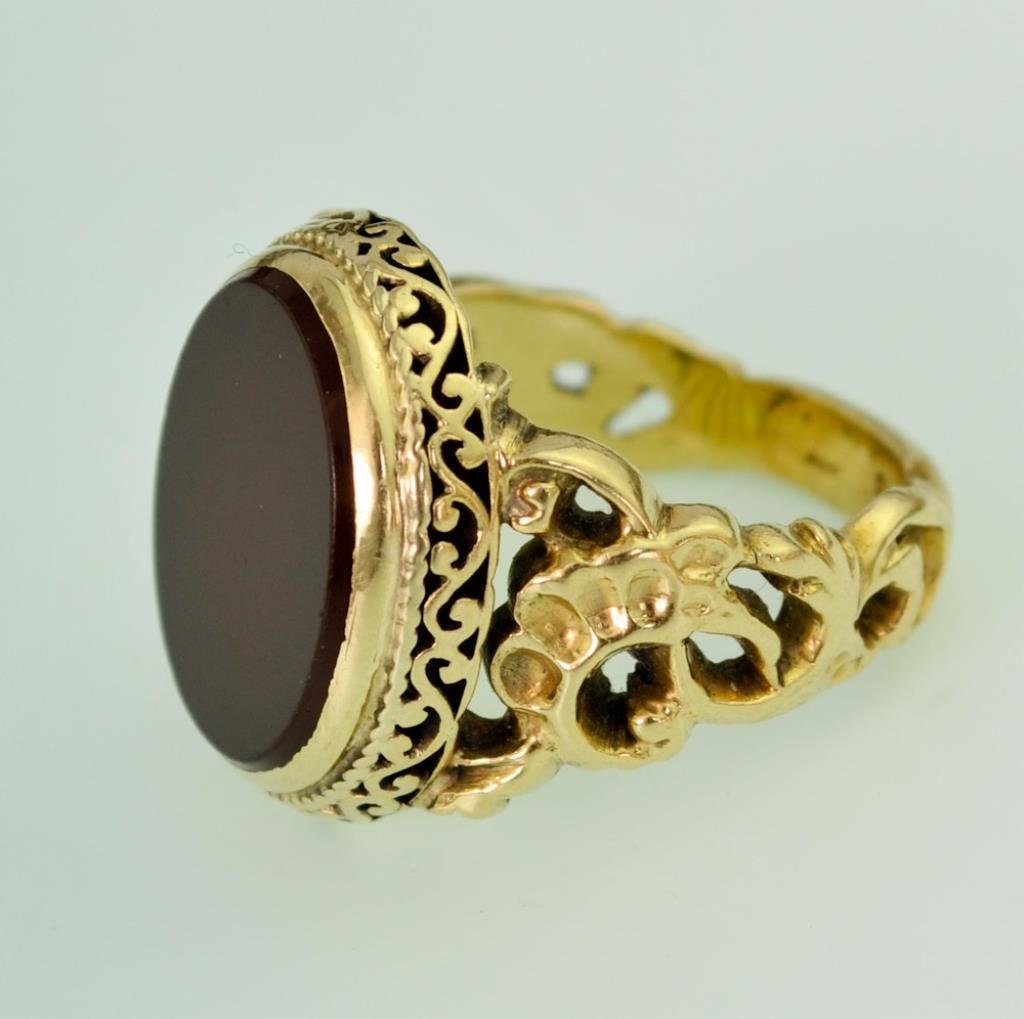 Gentleman's 14kt Gold Carnelian Ring: Oval polished carnelian in a 14kt (tested) yellow gold mounting, gallery and sides decorated with scrolled openwork; size 9 1/2; carnelian approx. 9/16" x 11/16"; total weight 15.8 grams (Ref. 2B)