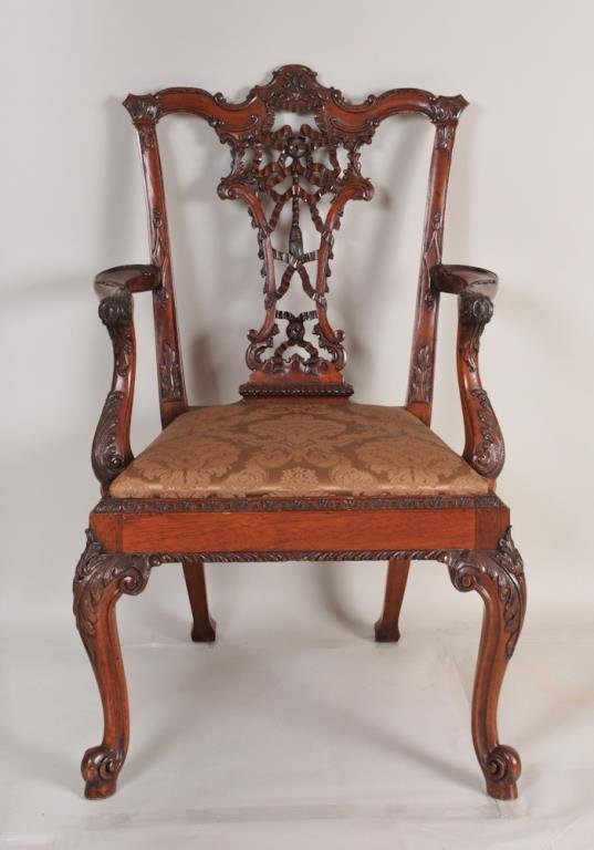 Carved Mahogany Chippendale Style Open Armchair: Having a shaped carved crest rail above a pierced carved ribbon and tassels splat, brown damask upholstered seat raised on acanthus carved cabriole legs ending in scroll toes, 20th century; 41"H, 26 1