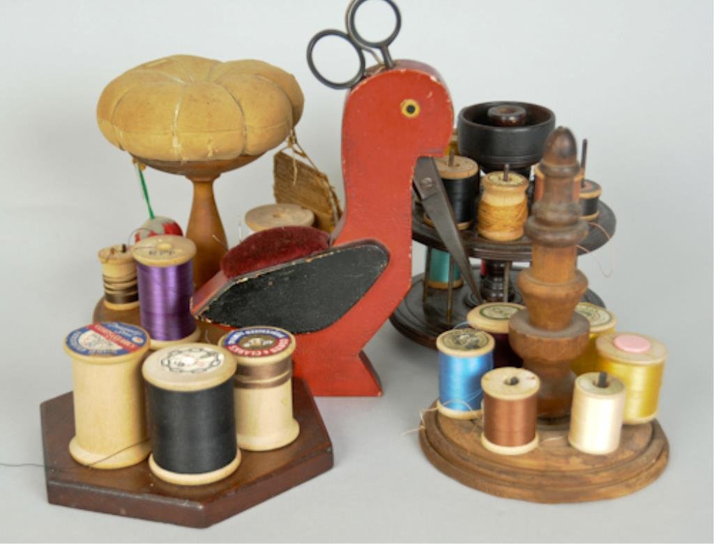 Four Wooden Sewing Spool Caddies: American, late 19th/early 20th century: 1. Circular base with metal posts for spools, central turned column supports a pin cushion top; 5 1/4"H----2. Circular two-tier form, revolving top tier lifts o