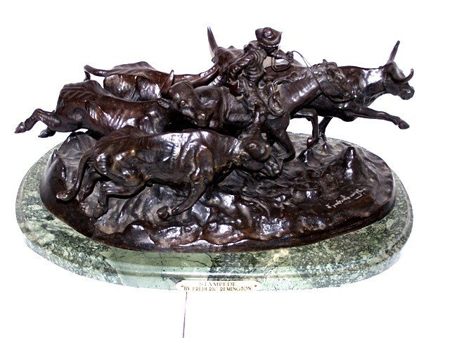 After Frederic Remington Bronze Sculpture: A bronze sculpture, "Stampede," signed in the bronze and mounted on a marble base. Condition is good. A wonderful recast of the original work of Frederic Remington. Length: 16 ½"