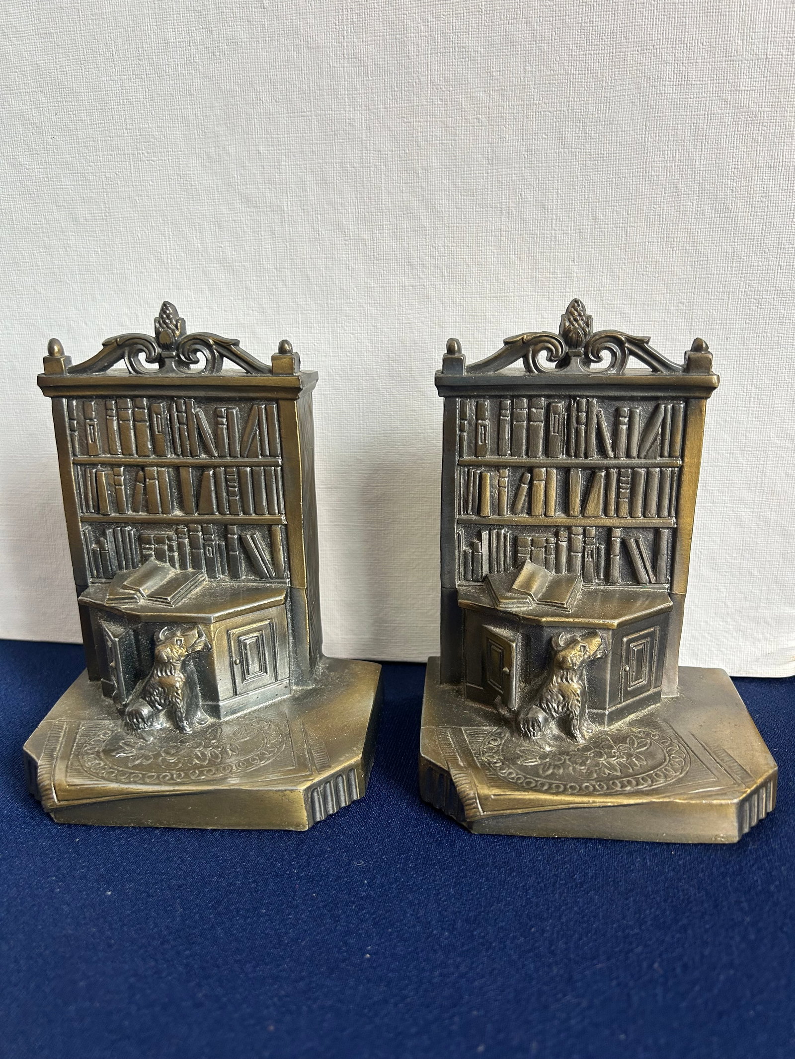 BOOKCASE BOOKENDS WITH TERRIER: BOOKENDS WITH A BOOKCASE AND TERRIER SCENE, METAL AND STAMPED, 4'' TALL, 4.5''WIDE