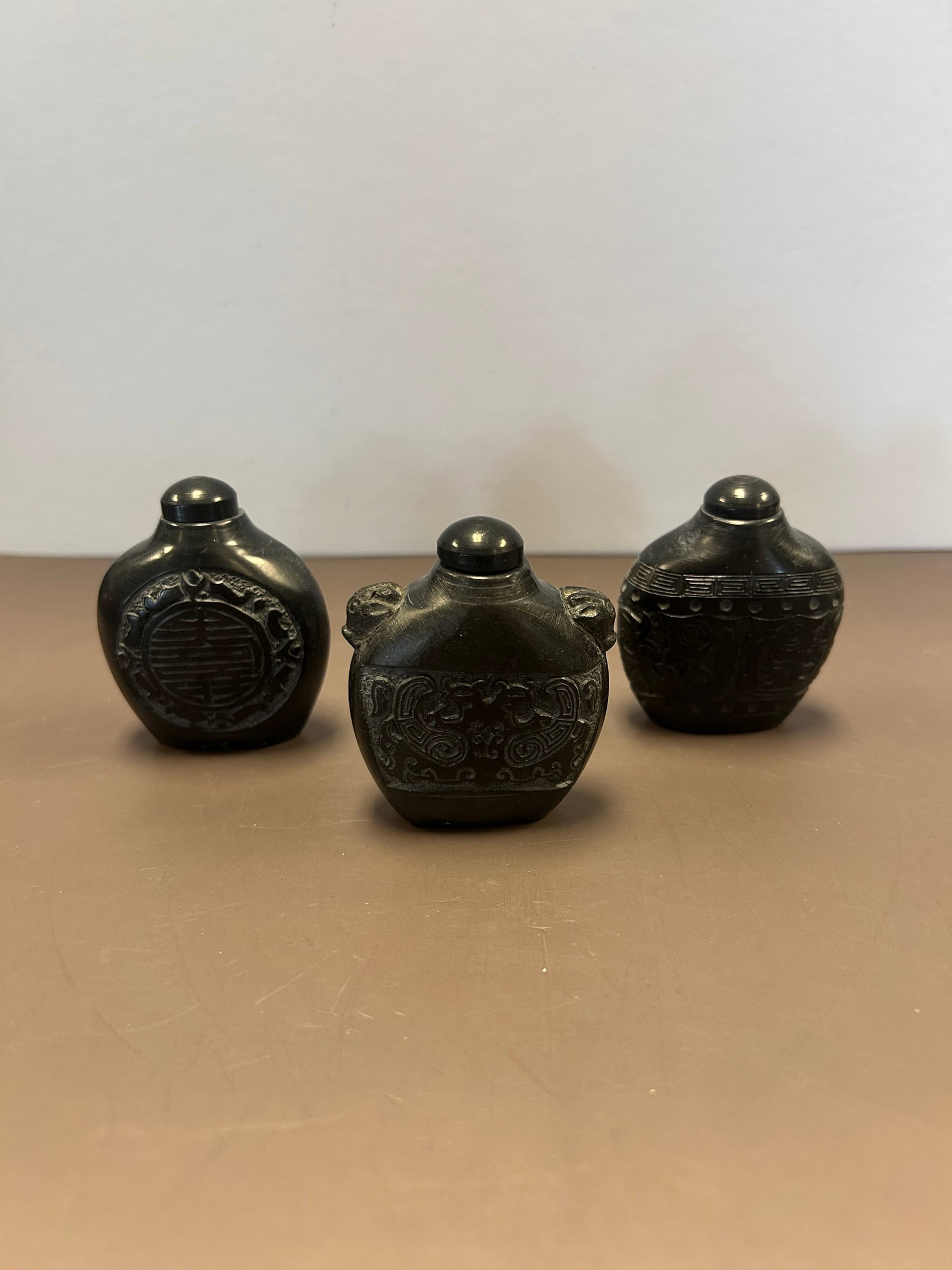 BLACK CINNABAR SNUFF BOTTLES: BLACK CINNABAR SNUFF BOTTLES, IN CASE, 3 TOTAL. ALL APPROX 2.5''T X 2''W