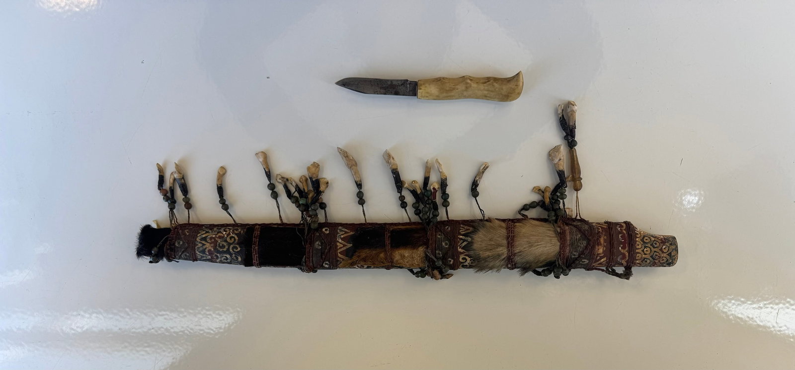 VINTAGE DAYAK MANDAU SCABBARD: APPROX 20.5", THIS IS THE SCABBARD ONLY (NO MAIN SWORD INCLUDED)SCABBARD IS HAND PAINTED, WITH FUR AND IS DECORATED WITH ANIMAL TEETH AND BEADS.BONUS 3" BLADE, ANTLER HANDLE UTILITY KNIFE TUCKED INTO 