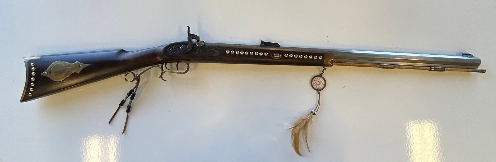 REPRODUCTION ANTIQUE HAWKEN RIFLE: MAKER-THOMPSON/CENTER S/N: K327356 CAL: .50MODERN REPRODUCTION OF AN ANTIQUE HAWKEN RIFLE, TACKED UP TO LOOK LIKE AN INDIAN GUN.GUN IS IN VERY NICE CONDITION.PROVENANCE: ESTATE OF DOUG DIVISH NORTH EA