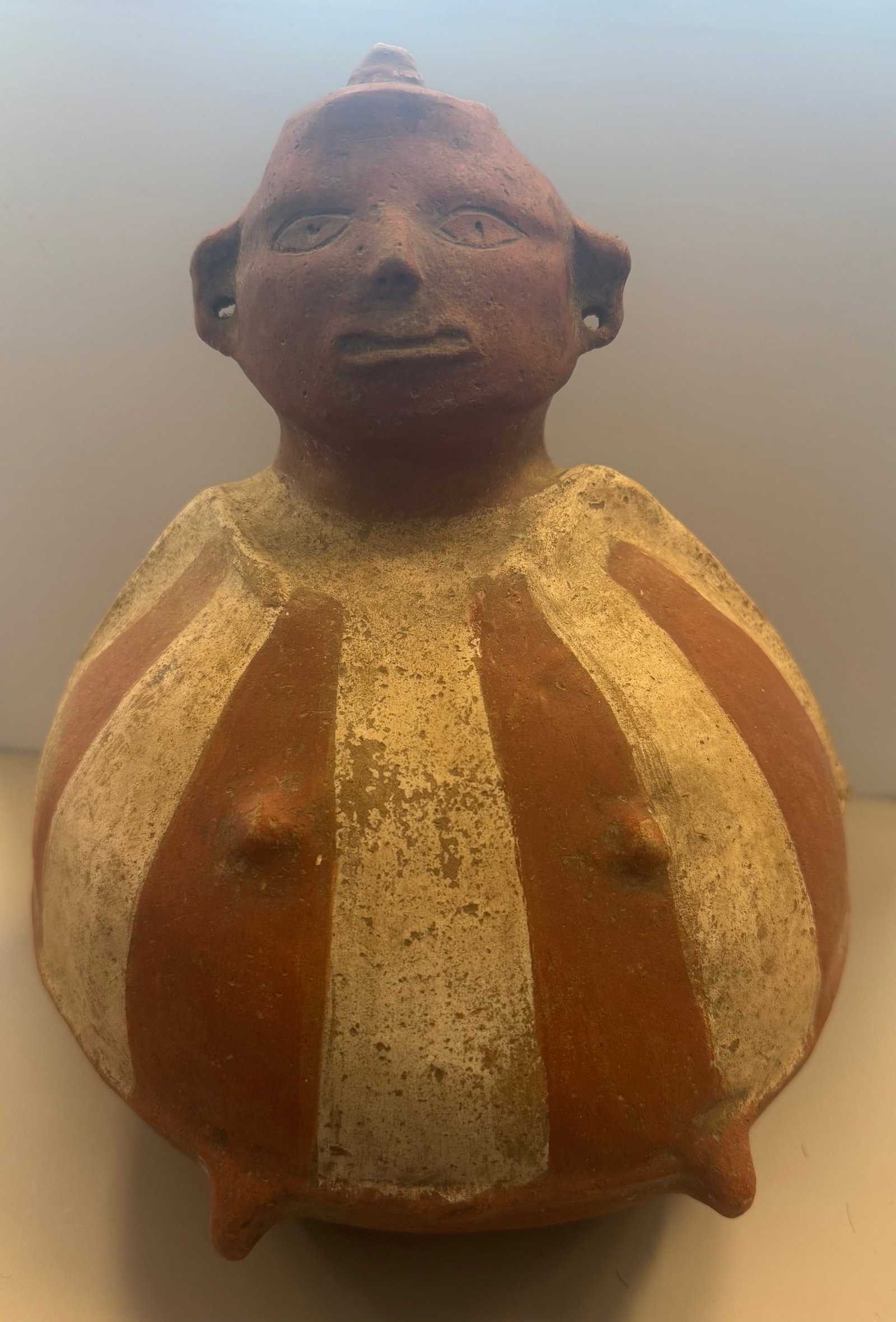PRE-COLUMBIAN STYLE EFFIGY JAR: PRE-COLUMBIAN STYLE ANTHROPOMORPHIC EFFIGY JAR, SPECIFICALLY RESEMBLING FERTILITY OR PREGNANCY VESSEL. FEATURES A BULBOUS LOWER BODY ADORNED WITH RED AND CREAM PAINTED VERTICAL PANELS.GOOD CONDITION11
