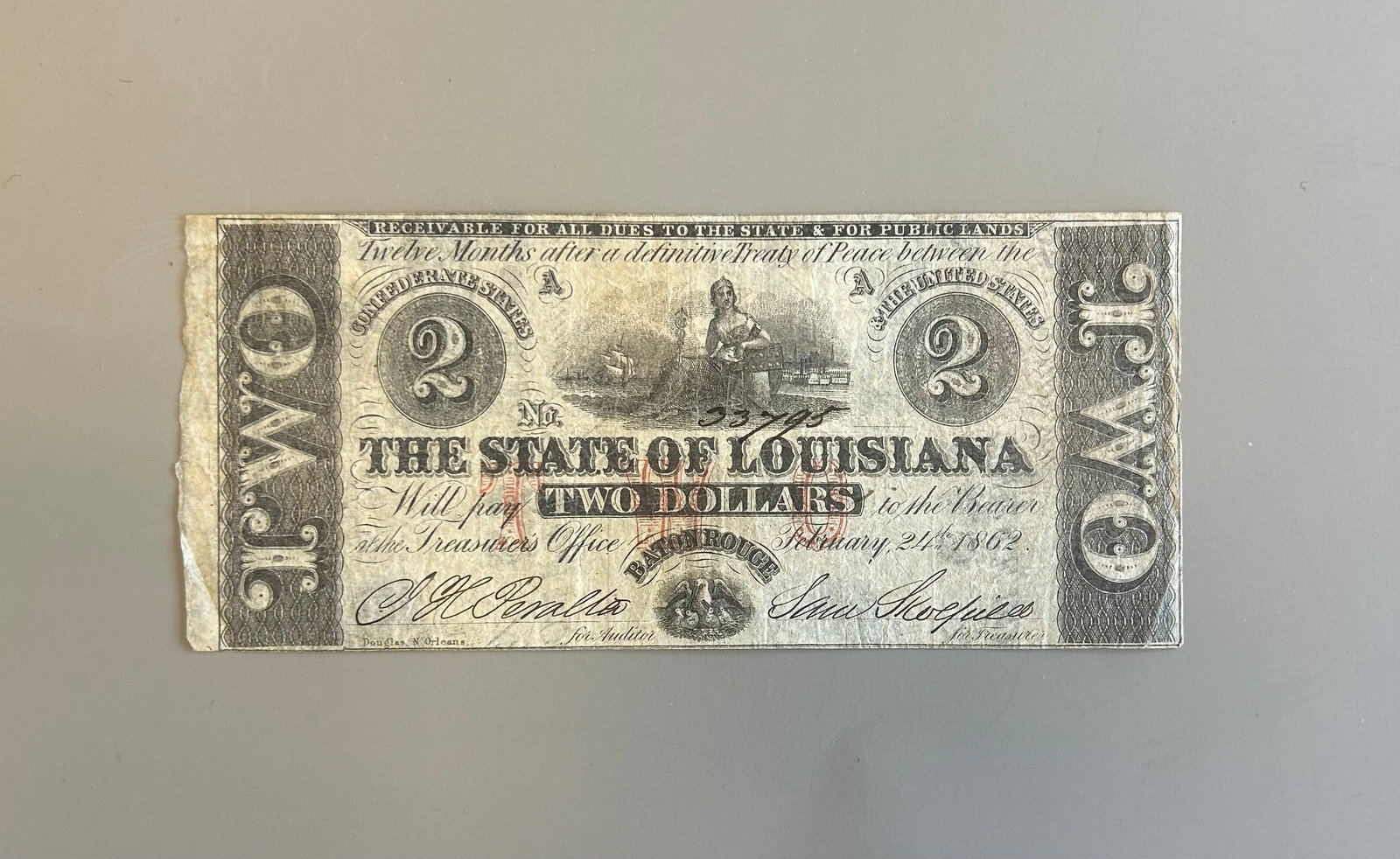 1862 CIVIL WAR-ERA $2 DOLLAR BANKNOTE: 1862 CIVIL WAR-ERA $2 DOLLAR BANKNOTE ISSUED BY THE STATE OF LOUISIANA. (BATON ROUGE ISSUE, DATED FEBRUARY 24TH, 1862).HANDWRITTEN SERIAL # 33795THE BACKSIDE OF THE BANKNOTE WAS PRINTED ON OBSOLETE CU