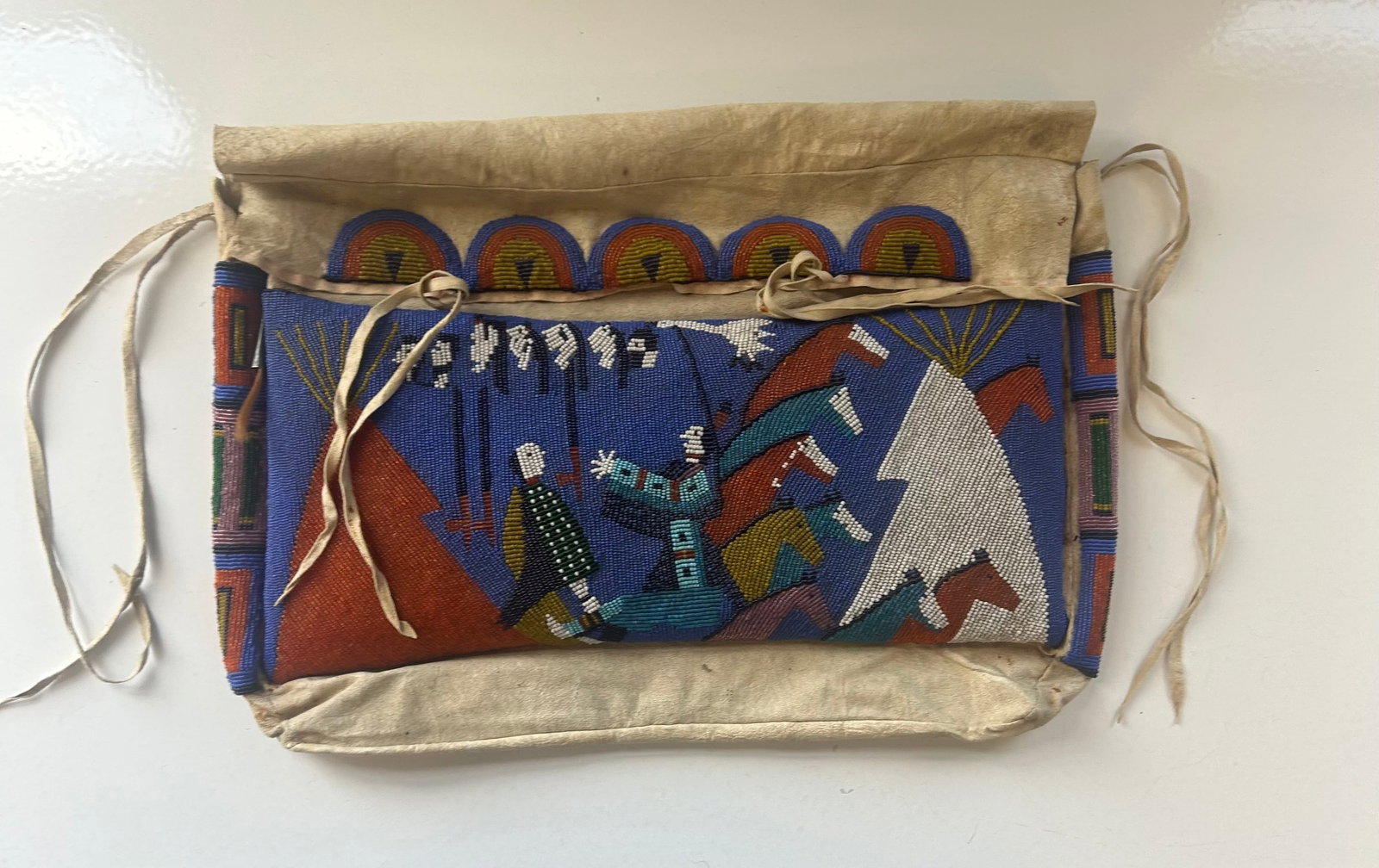 LAKOTA SIOUX BEADED TIPI BAG, WARFARE WITH HORSES: HIGHLY COLLECTIBLE LAKOTA SIOUX BEADED TIPI BAG, ''WARFARE WITH HORSES'' , BUCKSKIN AND GLASS BEADWORK, 18''WIDE, 14''LONG (POSSIBLE ARTIST NELLIE TWO BEAR GATES 1954-1935), PROVENANCE: ESTATE OF DOUG