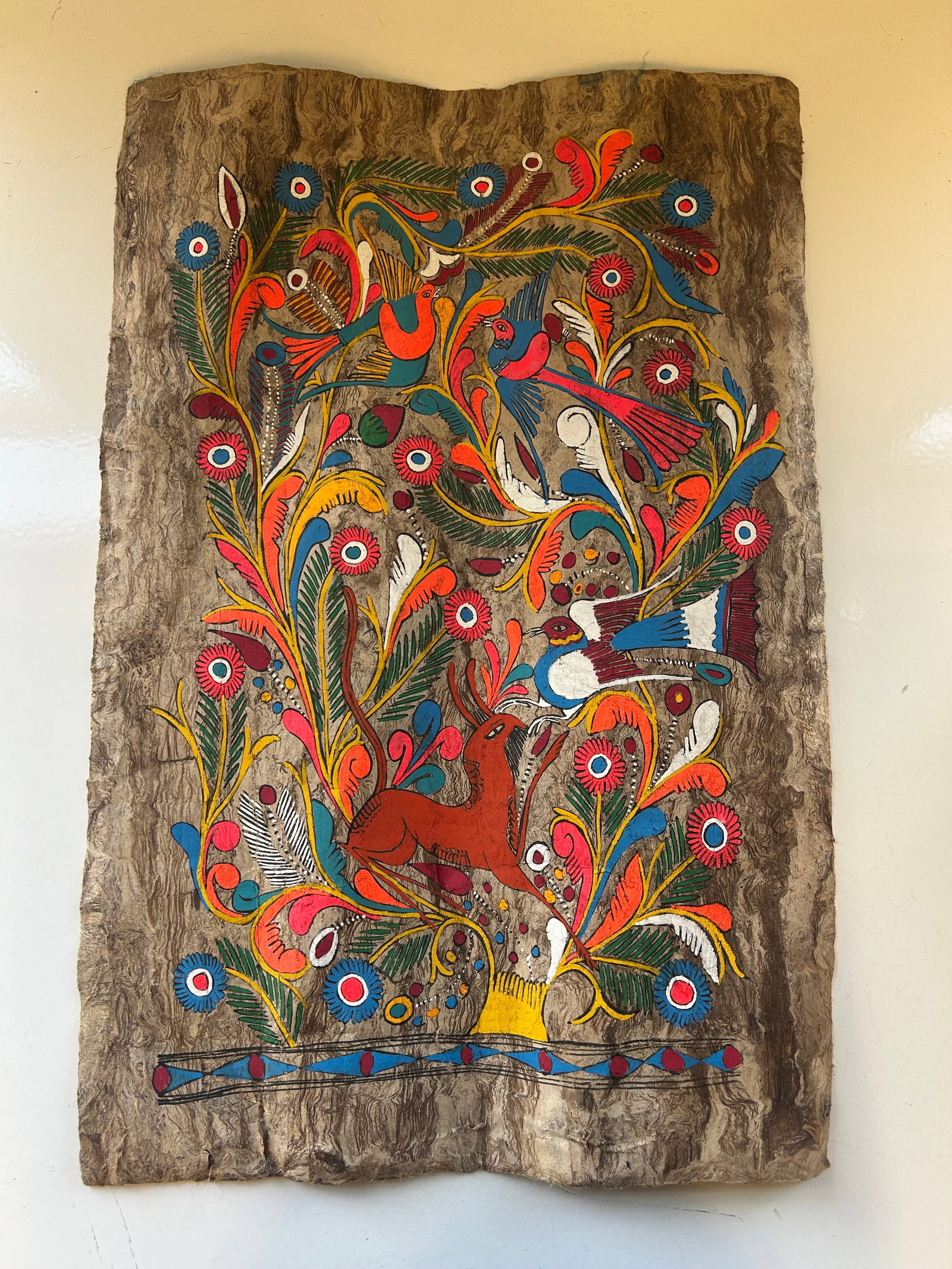 VINTAGE MEXICAN AMATE BARK FOLK ART: A STRIKING HAND PAINTED MEXICAN FOLK ART AMATE BARK PAINTING MEASURING APPROX. 28" X 19". THIS VIBRANT TREE OF LIFE COMPOSITION FEATURES COLORFUL BIRDS, FLOWERS, FOLIAGE, AND A DEER RENDERED IN