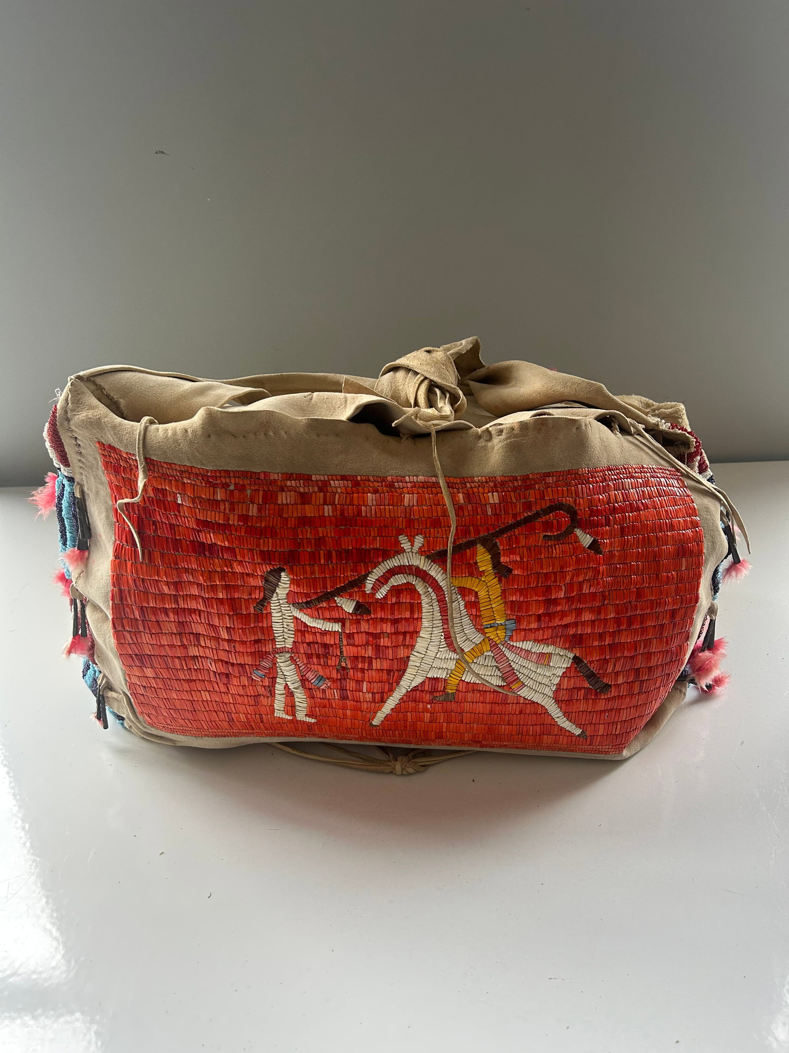 NATIVE AMERICAN PORCUPINE QUILL TIPI BAG: NATIVE AMERICAN TIPI HIDE BAG, 2 MEN AND A HORSE MOTIF, CHARECTERISTIC OF CHEYENNE OR SIOUX ARTISTRY, CONSTRUCTED WITH PORCUPINE QUILLS AND GLASS BEADS, 24''X11'', PROVENANCE: ESTATE OF DOUG DIVISH