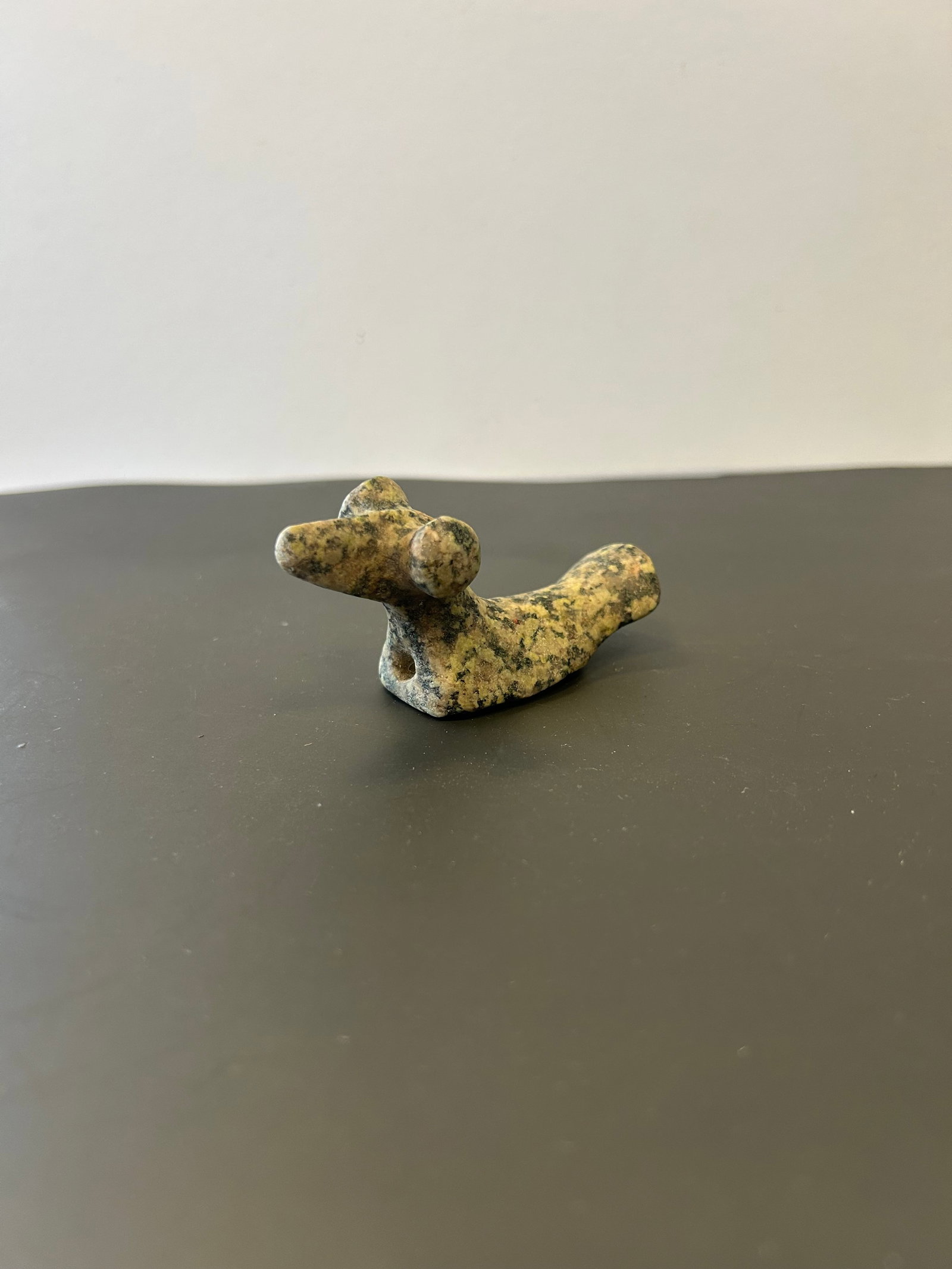 POP EYED BIRD STONE, FORT WAYNE, INDIANA: CARVED STONE BIRD EFFIGY WITH PROMINENT CIRCULAR EYES. MOUNTED PROVENANCE LABEL IDENTIFIES THE PIECE AS A " POP EYED BIRD STONE, FORT WAYNE, INDIANA." APPROX: 3 INCHES IN LENGTH. PROVENANCE: ESTATE