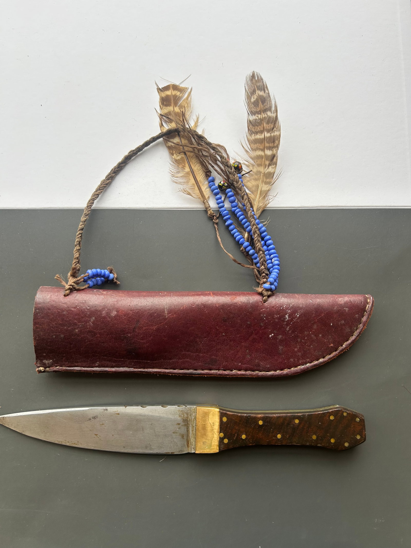 CUSTOM FIXED BLADE HUNTING KNIFE WITH SHEATH: CUSTOM FIXED BLADE HUNTING KNIFE FEATURING 6" BLADE AND DECORATIVE SPINE FILEWORK, BRASS GUARD AND HARDWOOD GRIP SCALES SECURED WITH BRASS PINS. ACCOMPANIED BY A LEATHER SHEATH DECORATED WITH BLUE