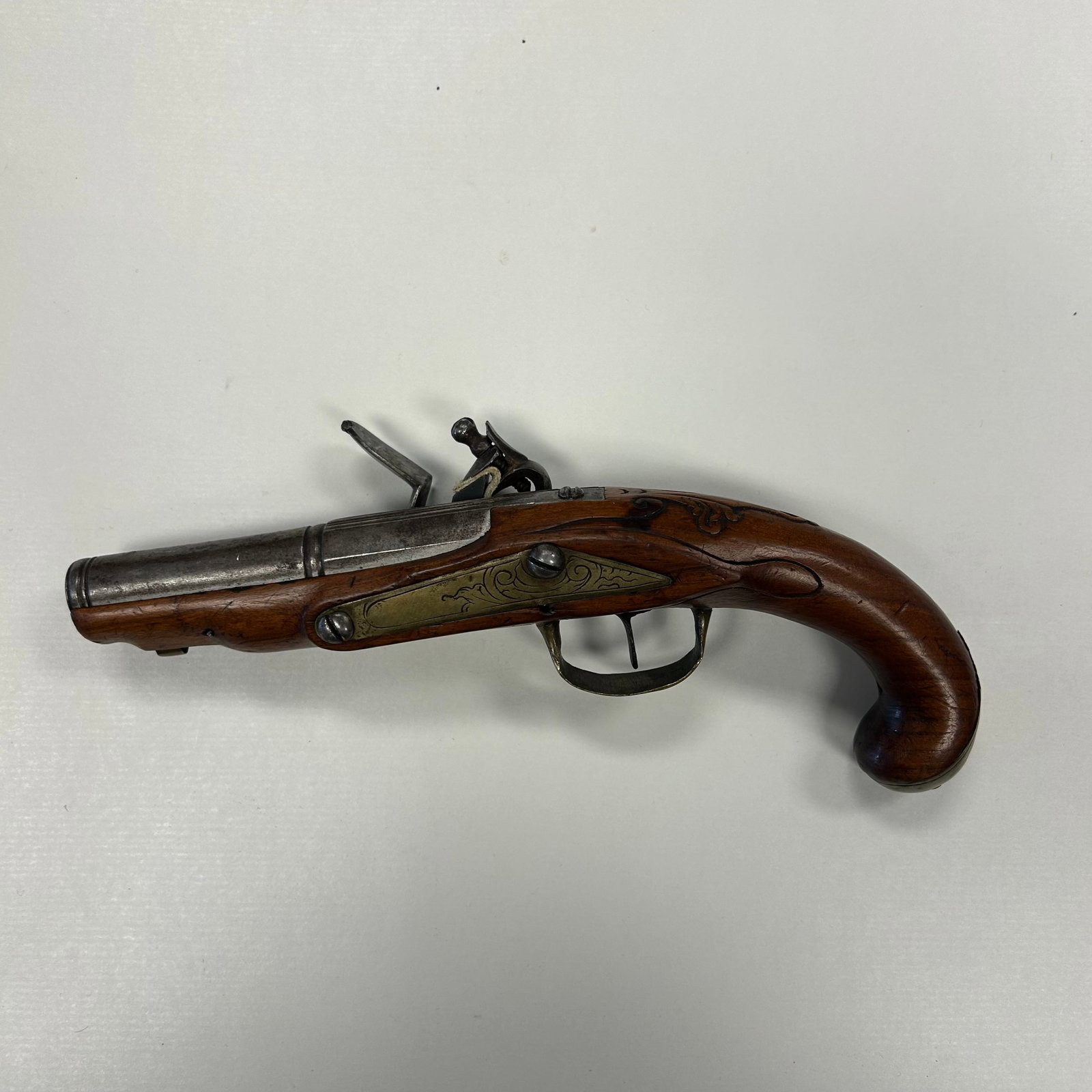 LATE 18th CENTURY ENGRAVED FLINTLOCK PISTOL: ATTRACTIVE ANTIQUE FLINTLOCK PISTOL, CIRCA LATE 18th CENTURY TO EARLY 19th CENTURY, FEATURING A FINELY ENGRAVED LOCK, CARVED WALNUT STOCK, ENGRAVED BRASS SIDEPLATE, BRASS TRIGGER GUARD, AND BRASS BUTT