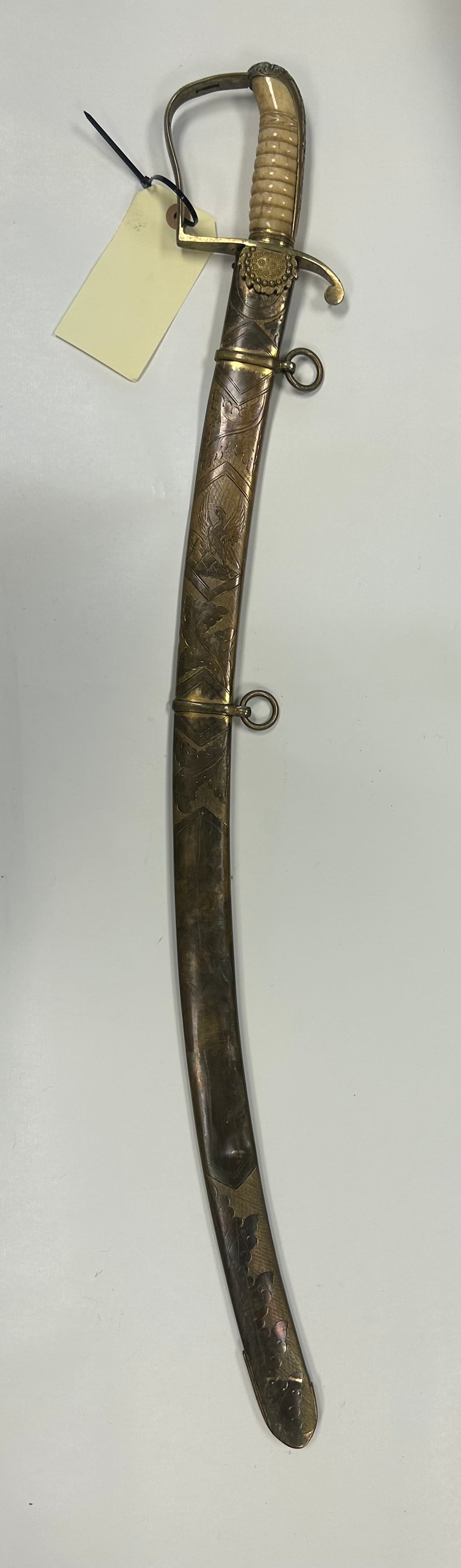 EARLY 19TH CENTURY AMERICAN EAGLE OFFICER'S SABER: IMPRESSIVE EARLY AMERICAN OFFICER'S SABER FEATURING A 30?" CURVED BLUE AND GILT DECORATED BLADE WITH EAGLE AND "E PLURIBUS UNUM" MOTIF, RIBBED LIGHT COLORED GRIP, BRASS HILT, AND ORNATE ENGRAVED BRASS