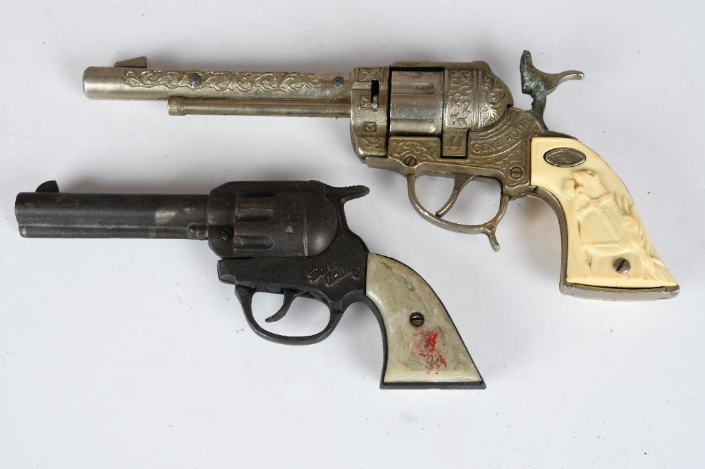 2-Gene Autry Toy Cap Guns: rated 7 & 8, the diecast L-H 44 is in good condition, the cast iron one the finish is tarnished.