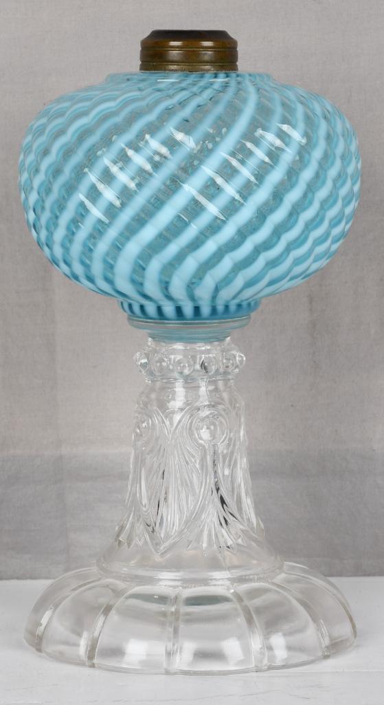 Blue Opalescence Oil Lampe: rated 9, 8.5"T., the oil lamp has a blue embossed opalescence swirl font, the press glass base and stem are clean.