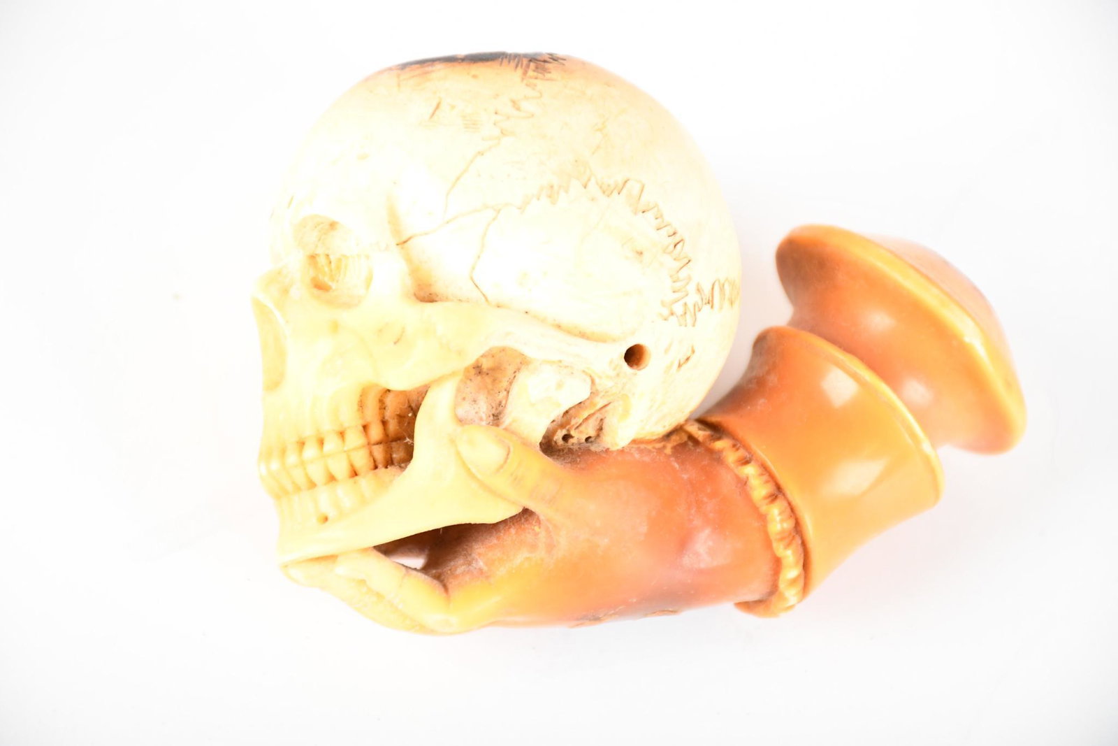 Meerschaum Hand Holding a Skull Pipe: rated 7.5, 2.5"H., has been used and has staining, comes with case.