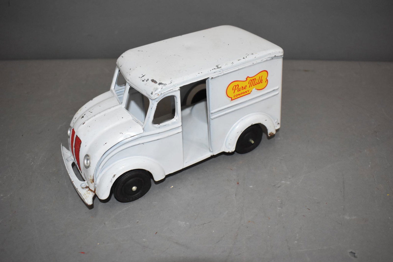 Keystone Press Steel Pure Milk Company Wind Up Delivery Truck: rated 7.75, 9"L., press steel truck has good color, has wear and tiny paint chips, motor works but is weak.
