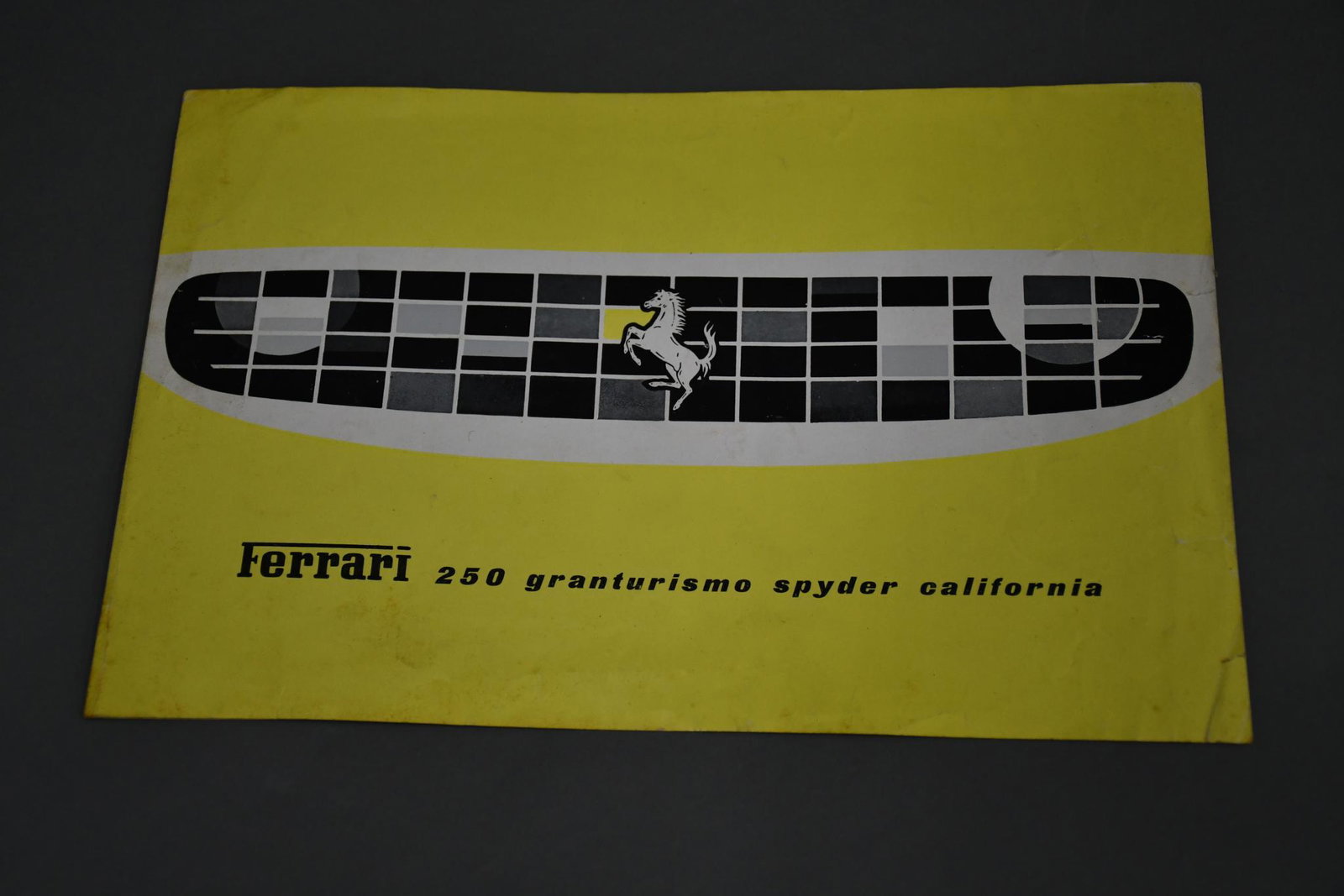 Ferrari 250 Granturismo Spyder California Sales Literature: rated 8.25, 7"x11", cover has light wear and a very small tear at the opening, opens up to black & white photos and specs facing it.