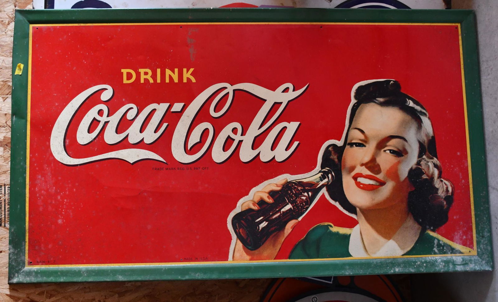 Drink Coca-Cola w/Lady Drinking a Coke Metal Sign: rated 8.25, 32"x56", SST self-framed sign has good color and shine, has minor wear and creases in the field, marked A.A.W.