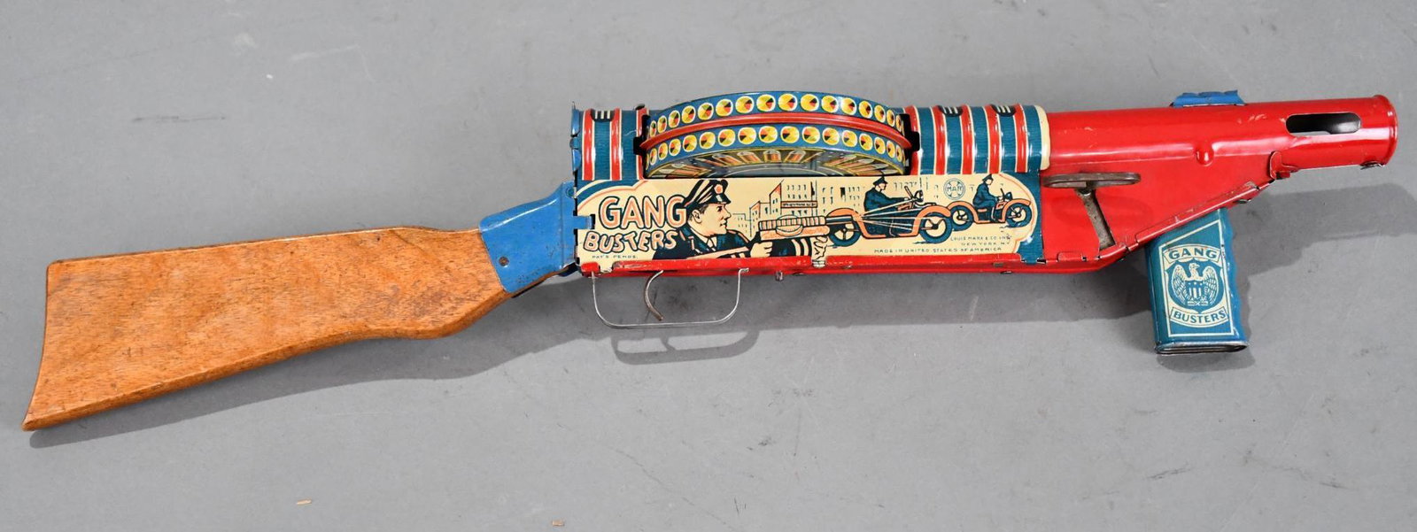 Marx Gangbuster "Crusade Against Crime Tin Litho Windup Toy Gun w/Box: rated 8.9, 23"L., the tin litho windup toy gun has very good color and shine, has light wear, has wood stock, windup works weel, box has damage and has been flatten.