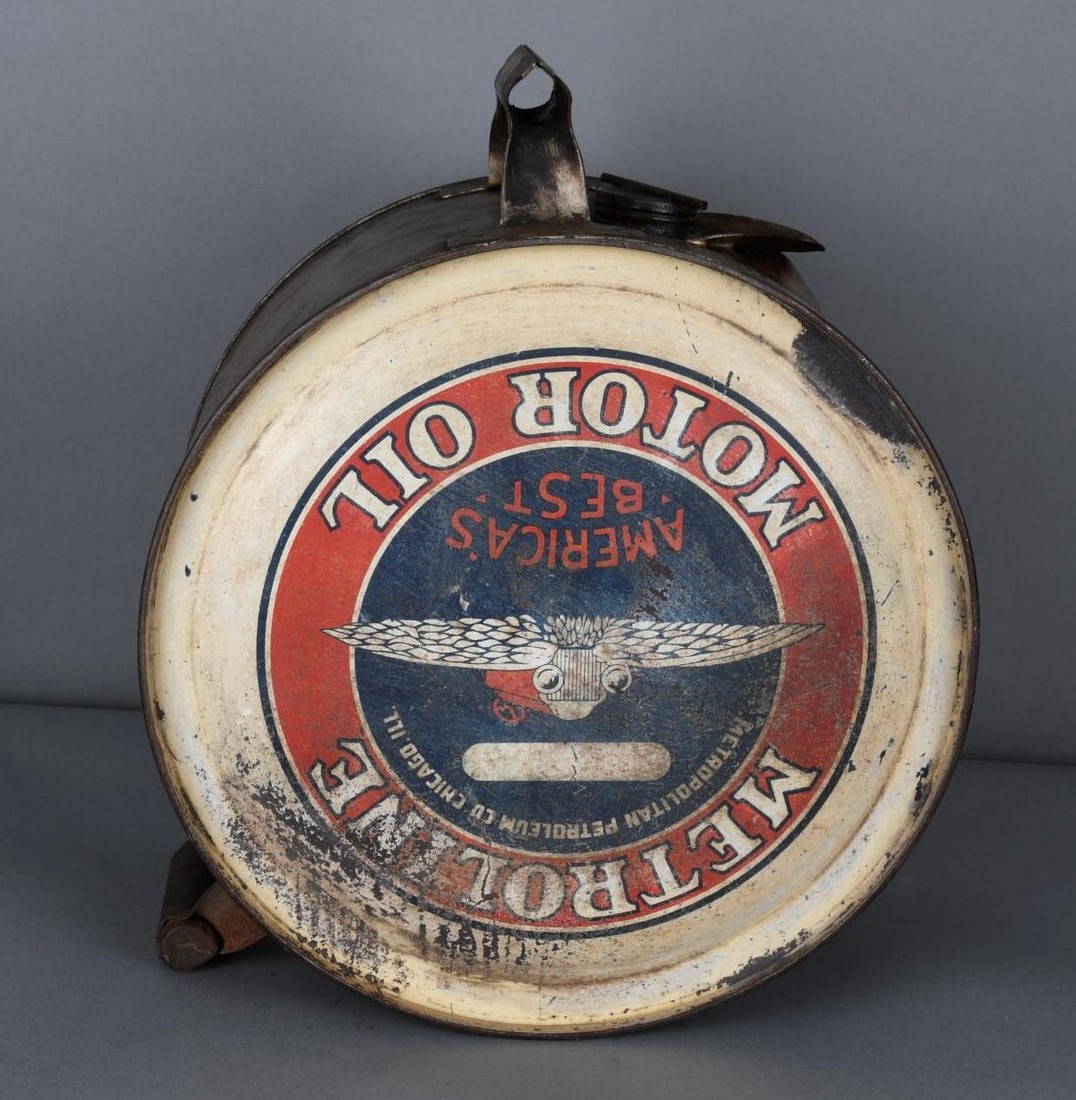 Metroleine Motor Oil w/Winged Car Logo Five Gallon Rocker Can: rated 5 & 6.5, the five gallon rocker can has heavy wear, reverse is worst, the display is a miss print it is upside down.