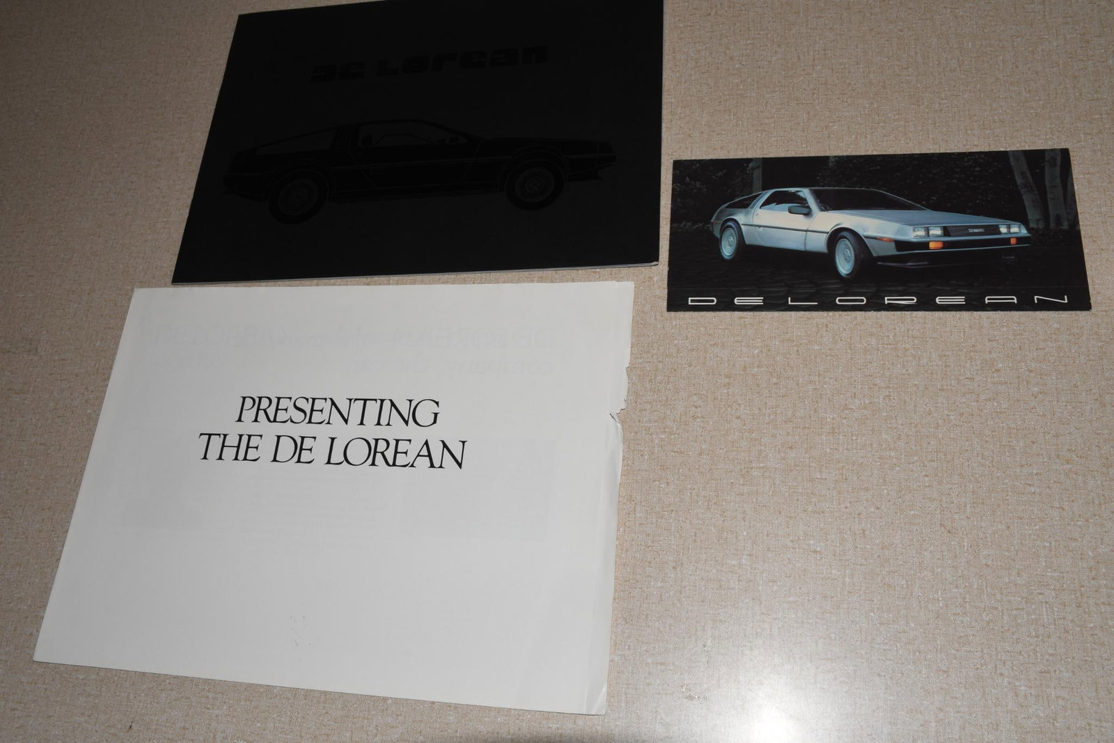 Lot of 3 Delorean Brochures - 3 (1981): 8.5"x12" or less in size, all in good condition, white one has wear, small one has writing.