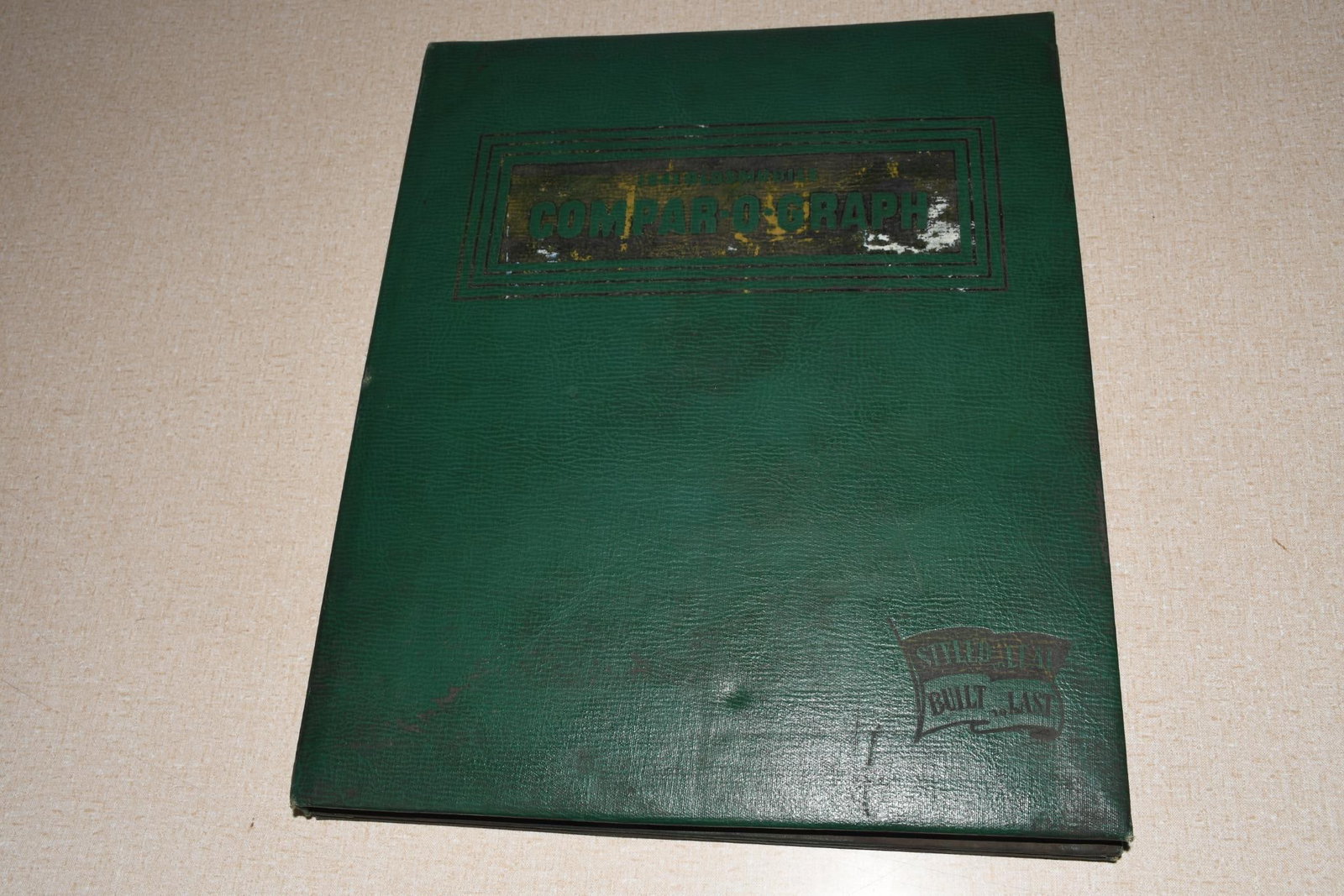1941 Oldsmobile Dealer Album Compar-O-Graph Competitor Model Comparisons: 15"x12", the book cover has wear and light soiling, inside pages some have minor moisture damage.