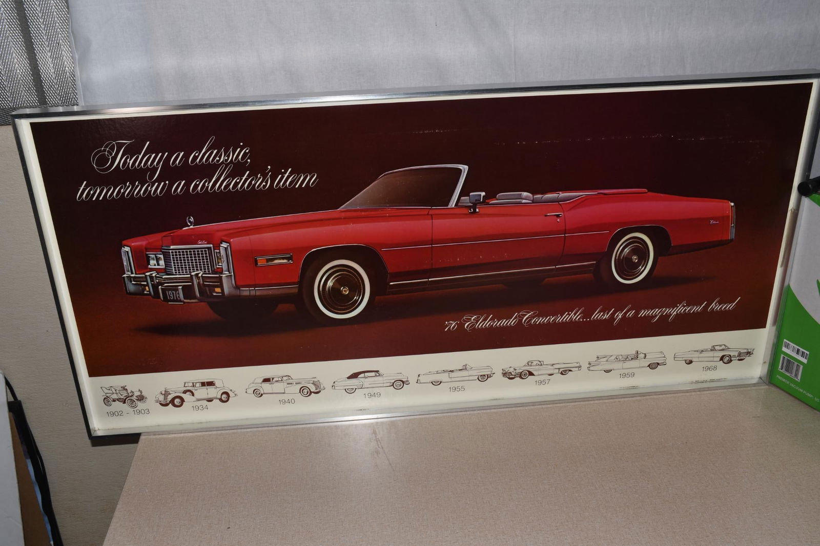 1976 Cadillac Eldorado Showroom Picture: 20"x42", the cardboard showroom poster in original metal frame and shipping box, poster has light wear.
