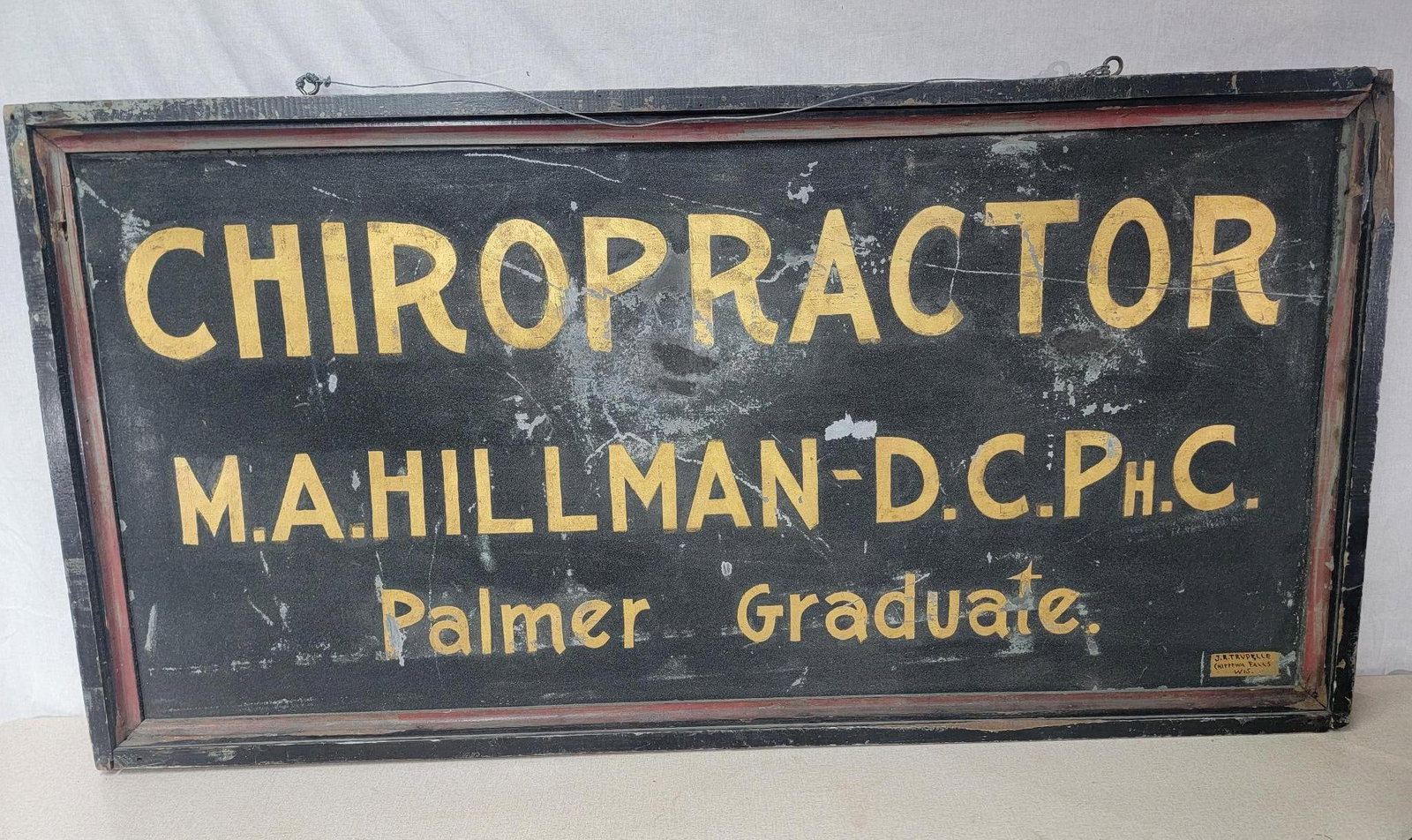 Chiropractor Hillman-D.C.Ph.C. Palmer Graduate Metal Smaltz Sign: rated 7.25, 27"x57", the DST smaltz painted sign has good color, has wear and scratches, is marked J.R. Trudelle Chippewa Falls Wis.