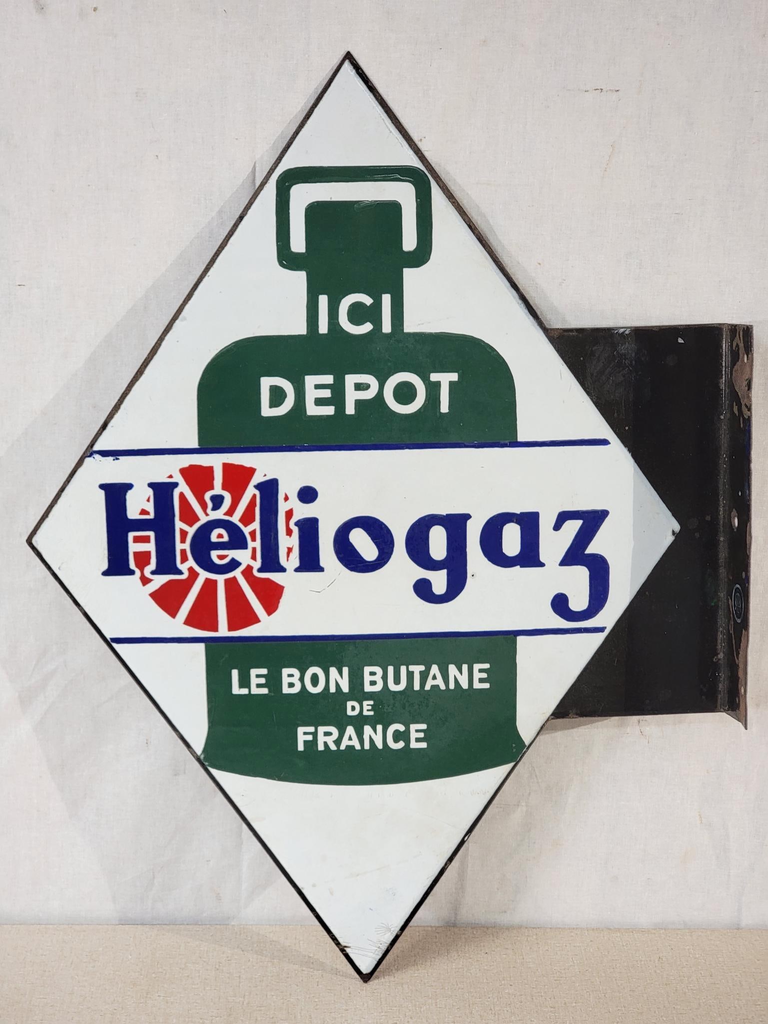 Heliogaz Butane ICI Depot Porcelain Flange Sign (TAC): rated 8.9 & 8.5, 23.5"x17.5", the diecut porcelain flange sign has good color and gloss, display has tiny chip in the field and around the perimeter, reverse has large chip in the field. TAC #057552