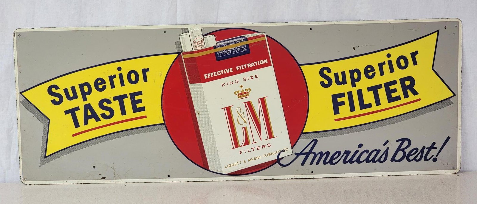 L&M Cigarette w/Logo Metal Sign (TAC): rated 7.9, 12"x34", the SST sign has good color and shine, has light wear and fine scratches. TAC #042863