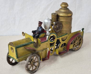 Schieble Toy & Novelty Co. Fire Engine: rated 7.5, 14.5"L., the metal and wood toy has wear and fine scratches, has touch ups on the wood boiler, has weight and drive works. The tank behind the driver has been repainted, Is ink stamped