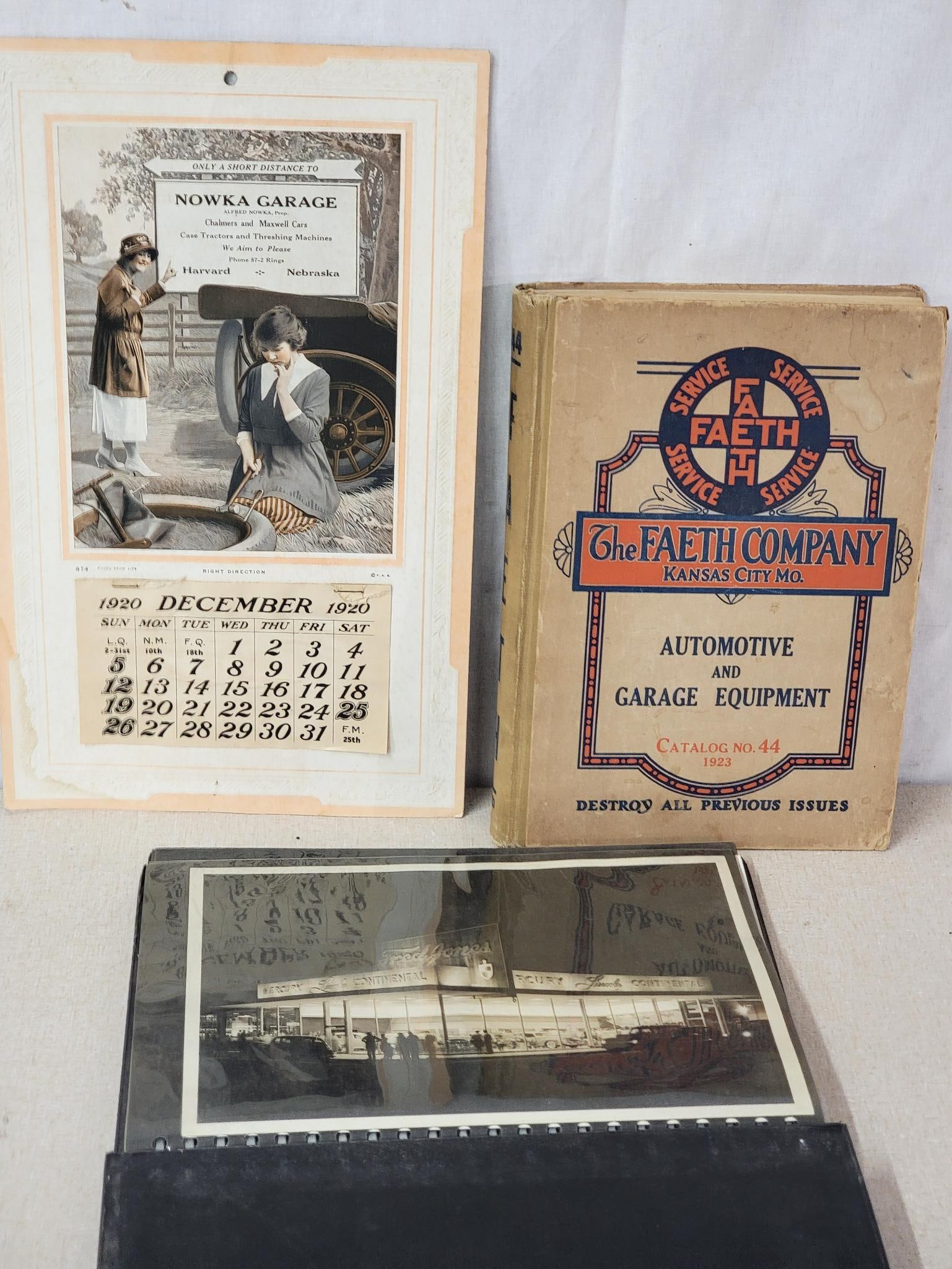 Photos of Jones Ford Ok City, 1920 Calendar and more: the photo album has several black & white photos of the dealership, 1920 calendar has 2-ladies changing a tire.