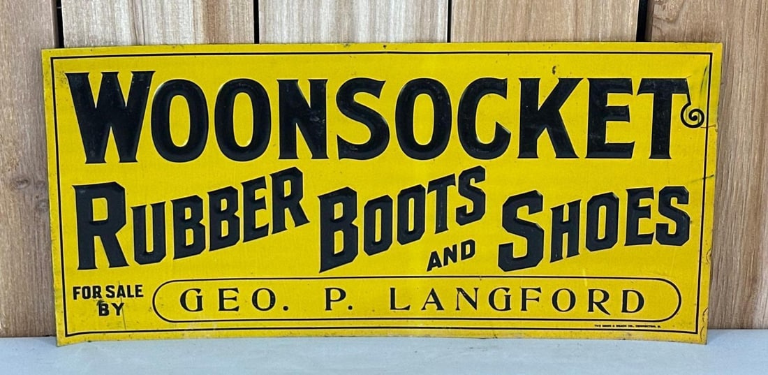 Woonsocket Rubber Boots & Shoes Metal Tacker Sign (TAC): rated 8.9, 9.25"x19.75", the SST embossed tacker sign has very good color and shine, has light wear, marked Meek & Beach. TAC #059393