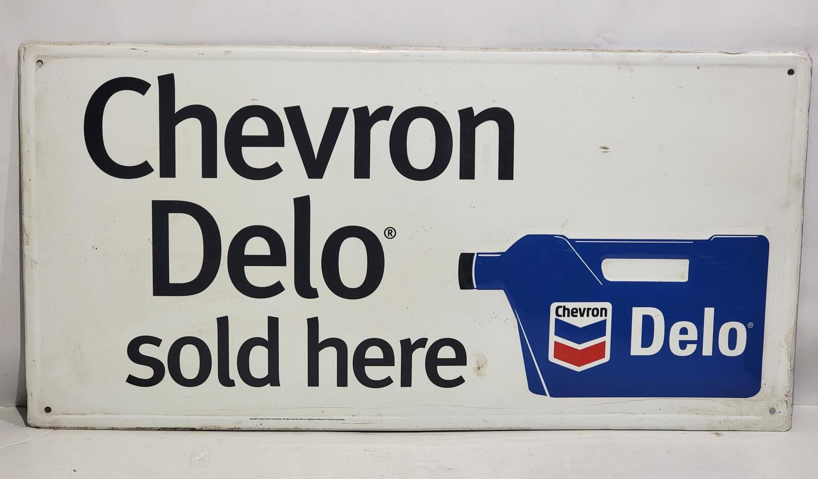 Chevron Delo Sold Here w/Plastic Oil Bottle Metal Sign (TAC): rated 8.9, 16"x32", the SST embossed sign has very good color and shine, has light wear, dated 1990. TAC #058702