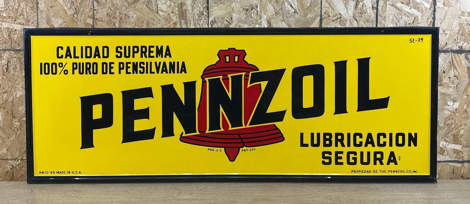 Spanish Pennzoil w/Red Bell Metal Sign: rated 9, 22"x58", the SST embossed wood backed sign has excelelnt color and shine, has marker in the upper right-hand corner. This lot can be picked up in Tidioute, PA on September 18 - 22 or 