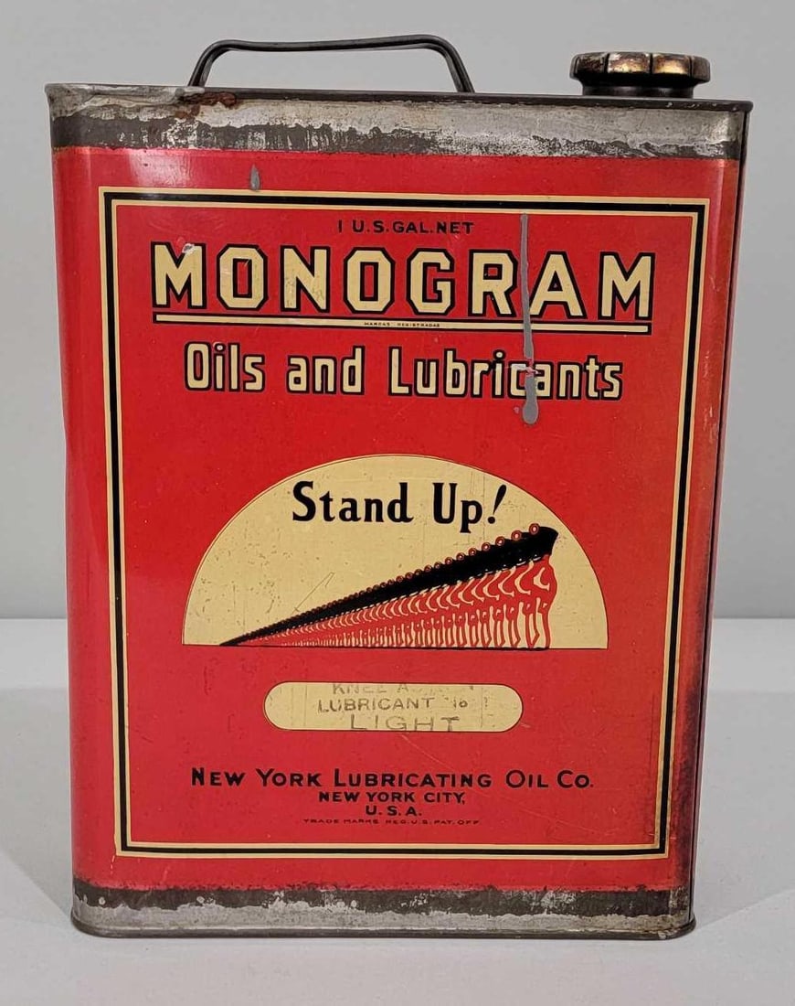 Monogram Oils & Lubricaants "Stand Up!" One-Gallon Flat Metal Can: rated 8.5 & 8. This one gallon flat metal can has good color and shine. Can shows light wear. Display has paint drip, reverse has staining along the edge. Can is empty, has lid. Rarity 6.