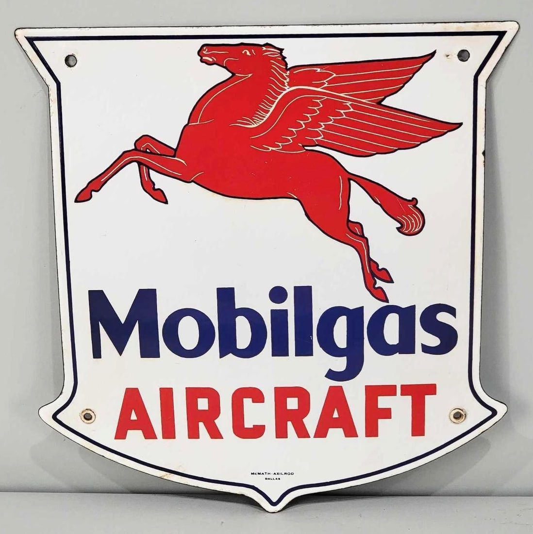 Mobilgas Aircraft w/Pegasus Porcelain Pump Sign (TAC): rated 9, 13"x12.5", the SSP shield-shaped sign has good color and gloss with a tiny chip near the top right mounting hole. Sign has minor wear around the perimeter. Marked McMath-Axilrod Dalla
