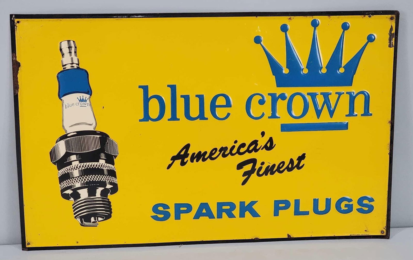 Blue Crown "America's Finest" Spark Plug Metal Sign (TAC): rated 8.25, 15"x24", the SST embossed sign has good color and shine, light wear in the field, more around the perimeter, marked Scioto. Rarity 5. TAC #061111