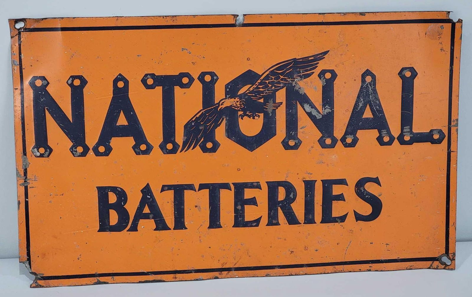 National Batteries w/Eagle Logo Metal Tacker Sign (TAC): rated 7, 12"x20", the SST embossed tacker sign has good color, has wear and paint chips in the field, has wear and damage around the perimeter. Rarity 5. TAC #061128