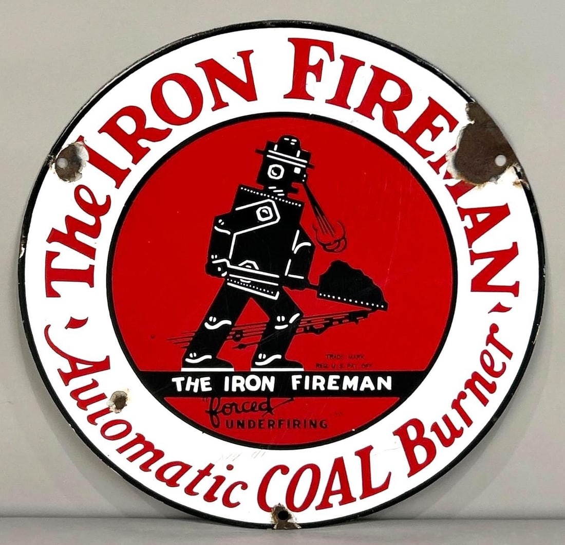 The Iron Fireman "Coal Burner" Porcelain Sign W/ Robotic Iron Fireman Graphic: Rated 8.25. 12" dia. This SSP sign has good color and throughout, with heavy surface scratching in the field. Display shows light porcelain loss on the outer field, as well as, on the outer edge.