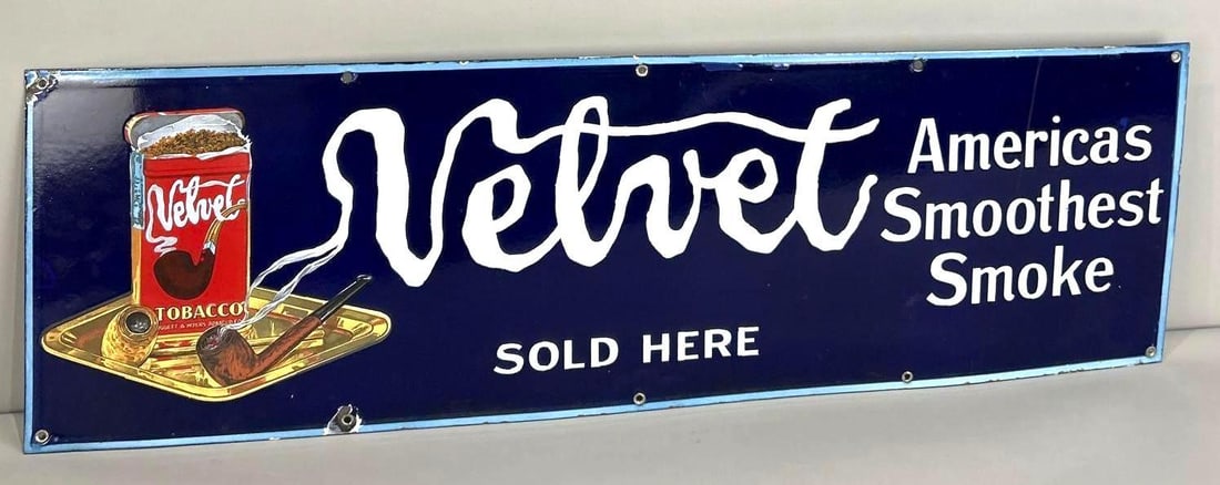 Velvet Tobacco Single-Sided Porcelain Sign W/ Smoking Pipe Graphic: (Rated 9.0). 12"x 39". This SSP sign has strong color and shine throughout. Sign shows minor surface stains in the field, as well as porcelain loss on the outer edge. Rarity 2. TAC # 062467 