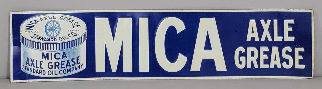 Mica Axle Grease w/Logo Metal Tacker Sign (TAC): rated 9, 4.5"x19.5". This SST embossed sign has excellent color and shine with only light wear. Sign has paper on the back. Rarity 3. TAC #061739
