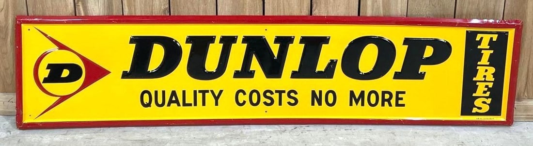 Dunlop Quality Costs No More Self-Framed Embossed Tin Sign: (Rated 9.0). 14" x 60". This SST sign has excellent color and gloss throughout. Sign shows light scratches on raised letters and "Tires" panel. Self-Framed edge has scratches with